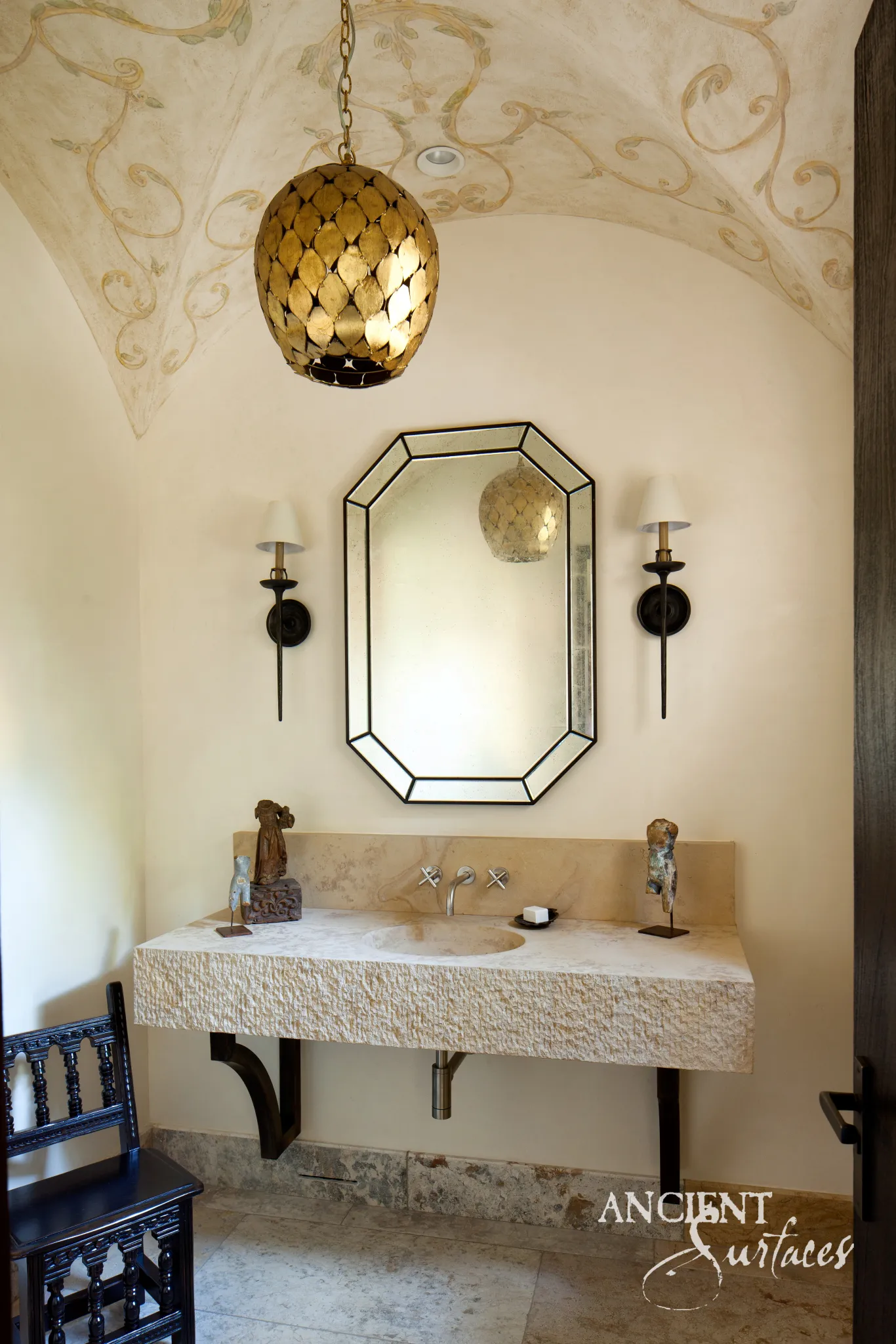 Solid reclaimed limestone floating vanity with a hand-hollowed oval basin and chiselled front face