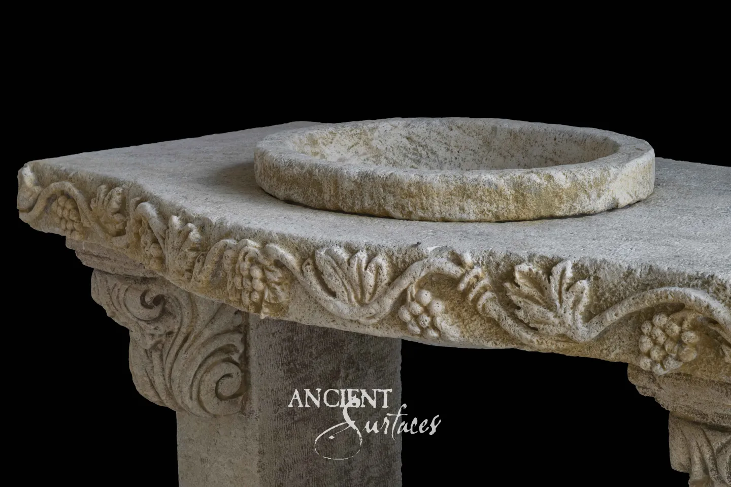 Round reclaimed limestone basin carved with a grapevine border above a scrolled column capital
