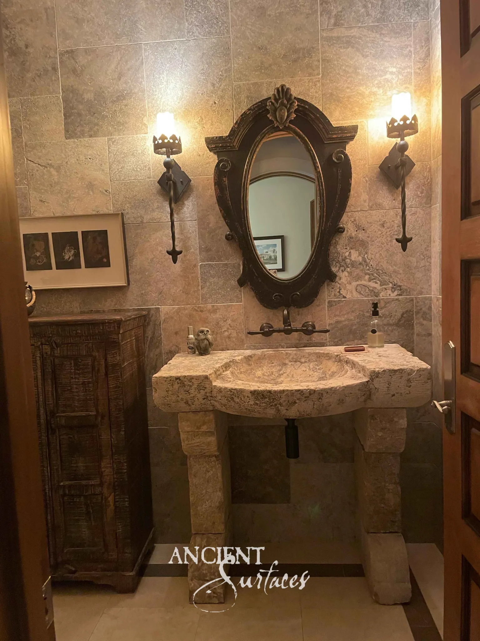 Freeform reclaimed limestone basin carved from a rugged block on two chunky stone-block legs